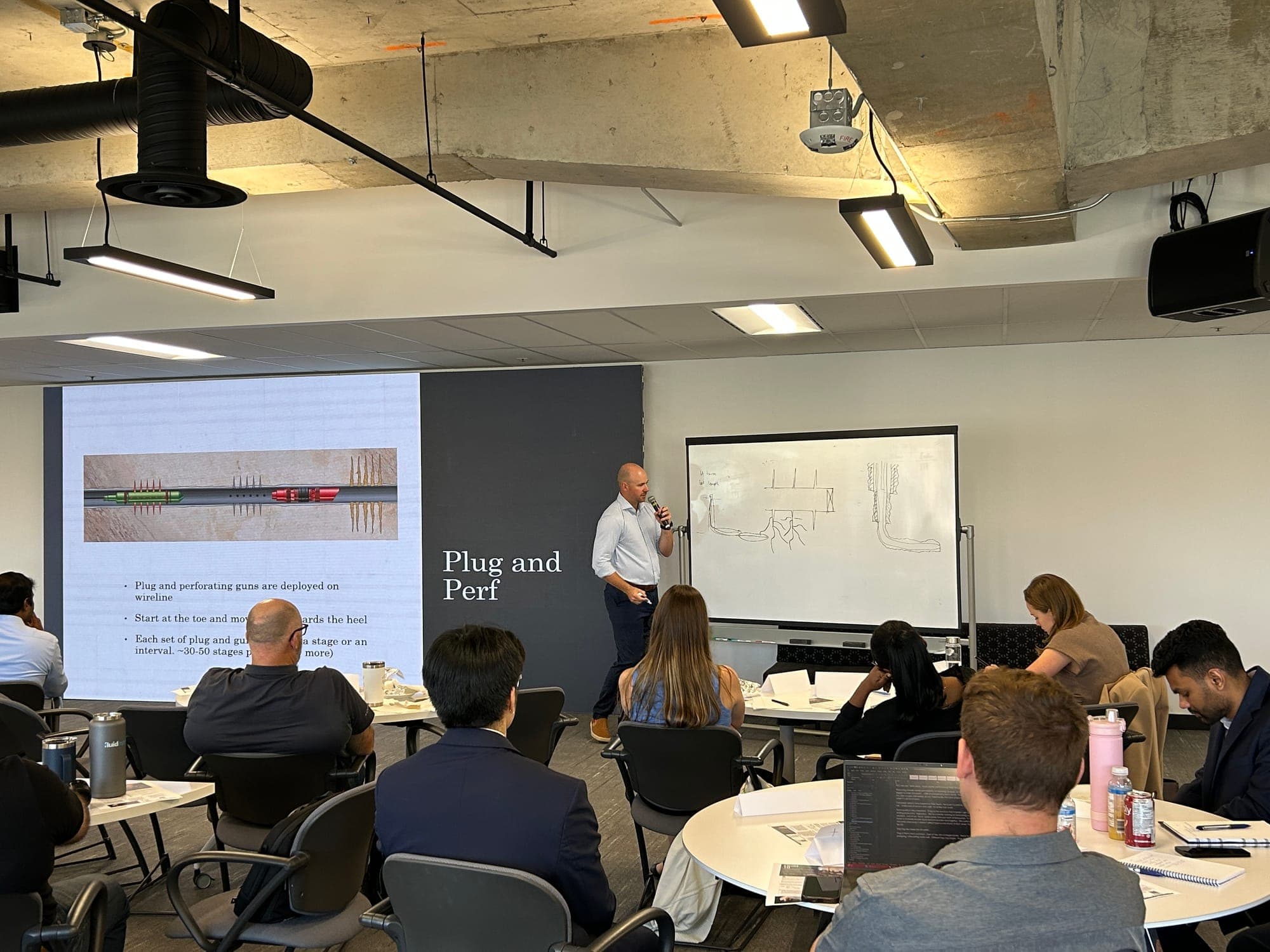 Brendan MacDougall teaching a plug-and-perf completions module with a wellbore diagram.